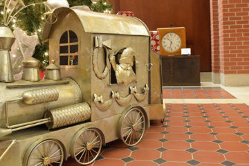 An image of a large train model placed at the base of a Christmas tree