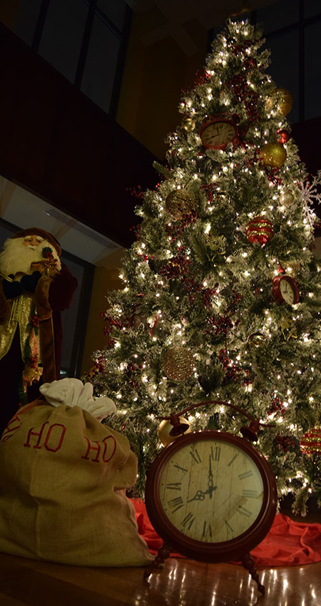 An image of a Christmas tree decorated with ornaments and lights and a stuffed Santa Clause