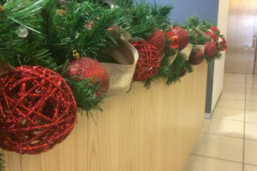 An image of garland and ornaments placed along a reception desk countertop