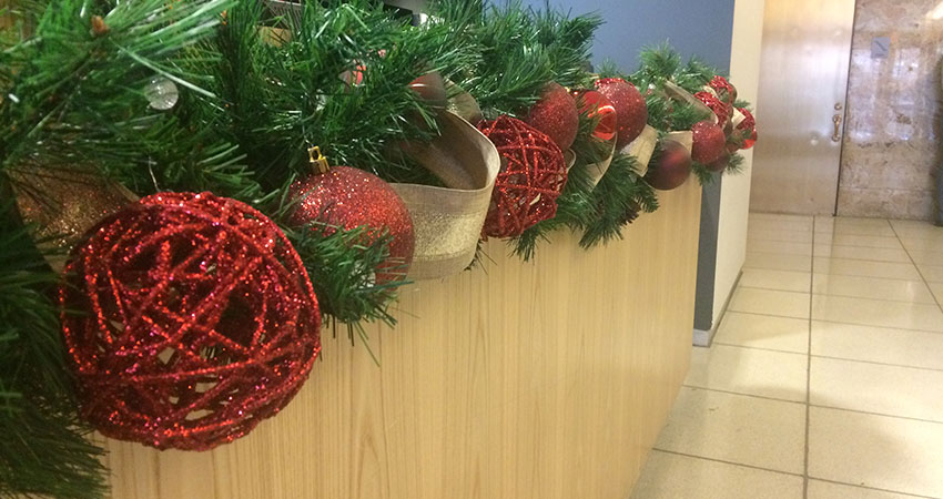 An image of garland and ornaments placed along a reception desk countertop